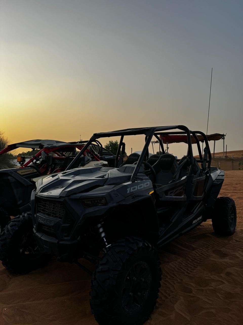 Polaris RZR 1000cc four-seater buggy pausing on a golden dune