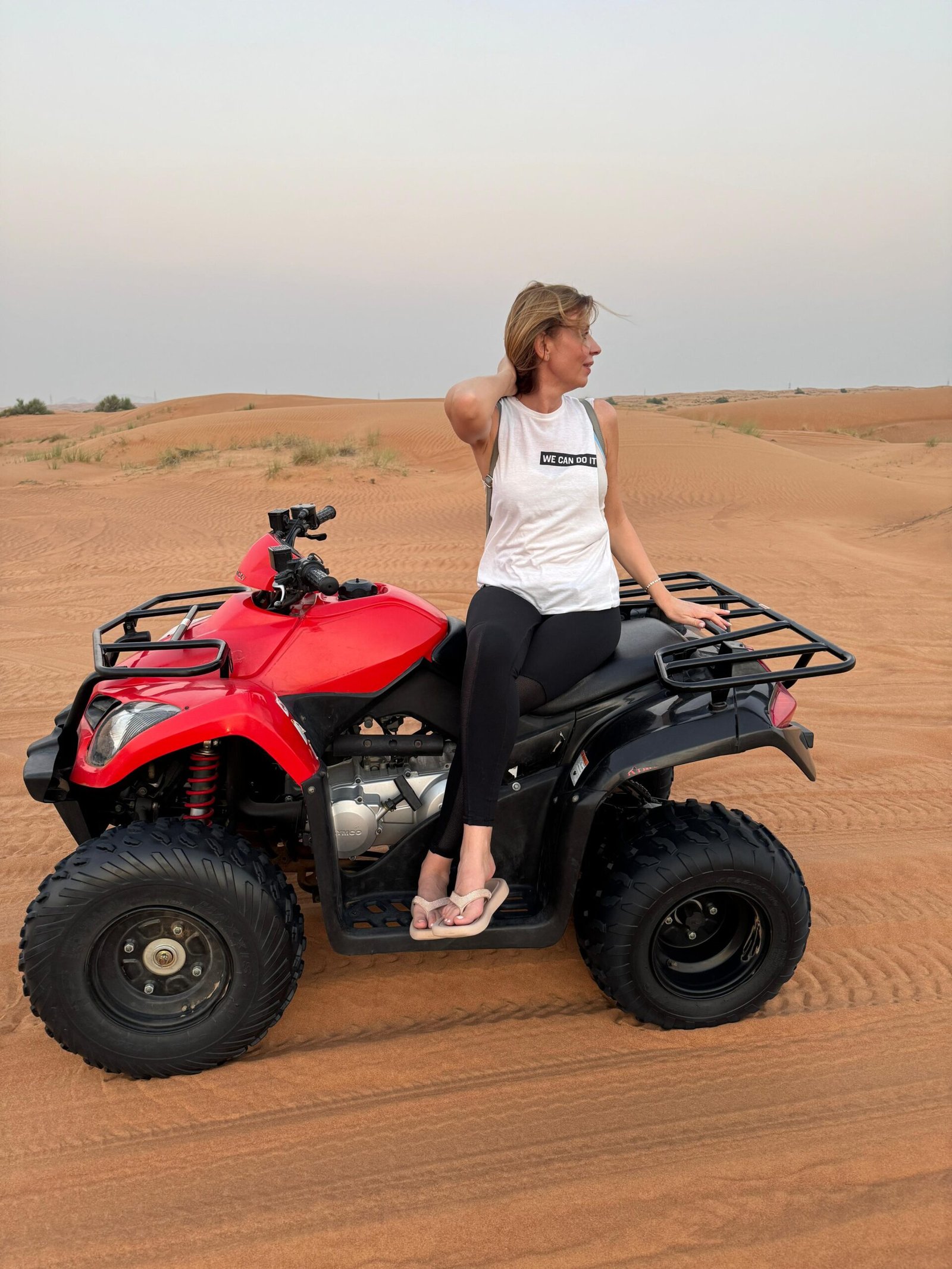 Action shot: 250cc quad climbing a dune